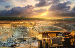 Yellow dump truck loading minerals copper, silver, gold, and other  at mining quarry.